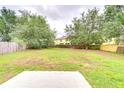 Expansive backyard with mature trees and wooden fence, offering privacy and space for outdoor activities at 538 Summer Sails Dr, Valrico, FL 33594
