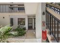 Inviting condo entrance with a staircase, tropical landscaping, and a visible fire extinguisher at 6265 Sun Blvd # 107, St Petersburg, FL 33715