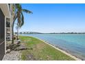 Scenic waterfront view featuring a lush green lawn leading to a calm body of water and bridge at 6265 Sun Blvd # 107, St Petersburg, FL 33715