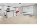 Spacious kitchen featuring white cabinets, a marble bar, and tiled floors at 817 E 145Th Ave, Tampa, FL 33613