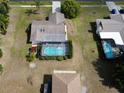 Aerial view of the property showcasing a private pool with screened enclosure and mature landscaping at 9304 Nile Dr, New Port Richey, FL 34655