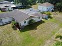 Wide backyard with mature trees, green lawn, white exterior paint, and backyard storage shed at 9304 Nile Dr, New Port Richey, FL 34655
