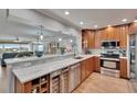 Open kitchen with marble countertops, stainless steel appliances, and bar seating to living area at 100 Bluff View Dr # 510A, Belleair Bluffs, FL 33770