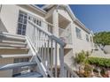 Exterior of the house showing white wooden stairways and a balcony in a lush tropical garden at 11520 Shipwatch Dr # 1385, Largo, FL 33774
