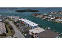 Aerial view of the building, adjacent boat docks, and neighborhood on a sunny day at 12405 3Rd E St # 306, Treasure Island, FL 33706
