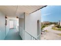 A well-lit hallway with blue floors and white trim leads to the units of the condo building at 12405 3Rd E St # 306, Treasure Island, FL 33706