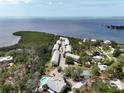 Gorgeous aerial view of waterfront condos featuring a pool, tennis court, and breathtaking bay views at 1500 Sunset Rd # C7, Tarpon Springs, FL 34689