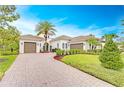 Beautiful home boasting a three-car garage, clay tile roof, and a meticulously designed front yard with palm trees at 15305 Fishhawk Preserve Dr, Lithia, FL 33547