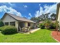 Charming home featuring a patio dining set, lush lawn, and a cozy outdoor living space, perfect for entertaining guests at 2459 Bay Berry Dr, Clearwater, FL 33763