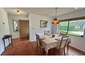 Cozy dining room with hardwood floors, a four-seater table, and a view of the outdoors at 2459 Bay Berry Dr, Clearwater, FL 33763