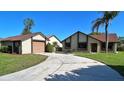 Exterior view of house and separate garage with winding driveway and established landscaping at 2459 Bay Berry Dr, Clearwater, FL 33763