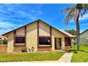 Well-maintained home with tan siding, brown trim, and a lush green lawn complemented by a mature palm tree at 2459 Bay Berry Dr, Clearwater, FL 33763