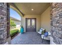Inviting front porch with seating and decorative stone columns at 2495 Oakwood Preserve Dr, Wesley Chapel, FL 33543