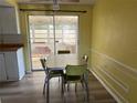 Bright dining area adjacent to kitchen, with table, chairs, and sliding glass door to porch at 3330 Monticello St, Holiday, FL 34690