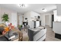 Inviting living room featuring modern decor, neutral tones, and seamless flow to kitchen with wood-look floors at 5111 N 30Th St, Tampa, FL 33610