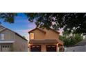 Two-story home showcasing a two-car garage, stucco exterior, and cozy architecture against a colorful sky at 5207 Moeller Ave, Sarasota, FL 34233