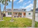 Charming home with a well-maintained lawn, and a welcoming front porch perfect for relaxing and enjoying the outdoors at 59 Acacia St, Clearwater Beach, FL 33767