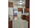 Functional kitchen with wood cabinets, white countertops, and tile flooring, ready for culinary adventures at 6012 Frond Way, Apollo Beach, FL 33572