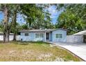 Light blue home with a well-maintained lawn and a new driveway and walkway at 6703 N Boulevard, Tampa, FL 33604
