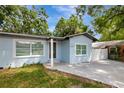 A front exterior of a light blue house with a new driveway at 6703 N Boulevard, Tampa, FL 33604