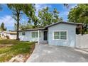 A front exterior of the light blue house with a well-maintained lawn at 6703 N Boulevard, Tampa, FL 33604