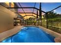 Covered outdoor pool with overhead lighting, deck area, and screened enclosure at 7029 Dowling Mill Cir, Tampa, FL 33625