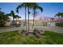 Charming single-story home featuring lush landscaping, a circular driveway, and an attached two-car garage at 7889 3Rd S Ave, St Petersburg, FL 33707