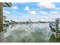A waterfront view featuring a boat docked alongside waterfront homes under a sunny, partly cloudy sky at 7889 3Rd S Ave, St Petersburg, FL 33707
