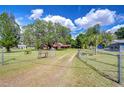 Spacious, gated front yard leads to a charming home surrounded by mature trees providing ample shade and privacy at 8320 Purvis Rd, Lithia, FL 33547