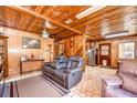 Cozy living room featuring warm wood paneling, comfortable seating and lots of natural light at 8320 Purvis Rd, Lithia, FL 33547