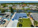 Waterfront home featuring a two-car garage, manicured lawn, and canal access at 1011 Spindle Palm Way, Apollo Beach, FL 33572