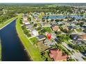 Aerial view showcasing the community with a pond, lush greenery, and well-maintained homes at 10540 Carloway Hills Dr, Wimauma, FL 33598