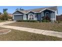 Charming single-story home with a well-maintained lawn, a two-car garage and manicured landscaping at 10540 Carloway Hills Dr, Wimauma, FL 33598