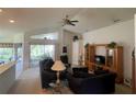 Relaxing living room with vaulted ceilings, sliding glass doors, and entertainment center at 11185 Heathrow Ave, Spring Hill, FL 34609