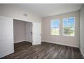 Cozy bedroom with wood floors, two large windows offering ample natural light at 12170 Cattleside Dr, Riverview, FL 33579