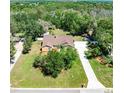 Expansive aerial view showcases a well-maintained home with a large yard surrounded by a lush tree canopy at 12408 Wexford Hills Rd, Riverview, FL 33569