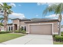 Charming single-Gathering home with a well-manicured lawn and attached two-car garage at 14227 Alistar Manor Dr, Wimauma, FL 33598