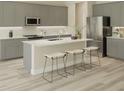 Modern kitchen featuring stainless steel appliances, gray cabinets and a quartz countertop island at 14427 Meadow Bird Ave, Riverview, FL 33579