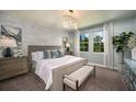 Serene bedroom with a decorative wall, chandelier, and bright windows that provide a scenic view at 14427 Meadow Bird Ave, Riverview, FL 33579