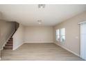 Bright and airy living room with wood-look floors, staircase and multiple windows at 14811 Summer Branch Dr, Lithia, FL 33547