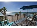 Relaxing balcony with ocean views, comfortable seating, and an umbrella for shade at 1600 Gulf Blvd # 212, Clearwater Beach, FL 33767