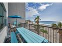 Balcony view of the beach with blue picnic table and seating at 1600 Gulf Blvd # 212, Clearwater Beach, FL 33767
