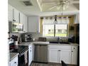 Efficient kitchen featuring white cabinets, stainless steel appliances, and ample counter space at 2513 Oakleaf Ln # 26C, Clearwater, FL 33763