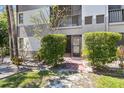 Charming condo entrance with well-maintained landscaping, brick pathway and screened porch for outdoor enjoyment at 2650 Countryside Blvd # B-110, Clearwater, FL 33761