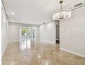Bright and spacious living room featuring tile flooring and a contemporary chandelier and natural light at 2650 Countryside Blvd # B-110, Clearwater, FL 33761