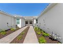 View of the landscaped walkway leading to the front of the home at 27153 Capri Shores Cir, Englewood, FL 34223