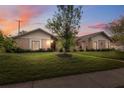 Charming single-story home featuring a brick facade, well-manicured lawn, and mature tree in the front yard at dusk at 2906 Beagle Pl, Seffner, FL 33584