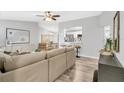 Bright living room with a ceiling fan, modern decor, open to the kitchen, and lots of natural light at 2988 Sugar Bear Trl, Palm Harbor, FL 34684