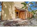 Close up of townhome entrance with wood fence and tropical foliage at 3604 Brigadoon Cir # 3604, Clearwater, FL 33759