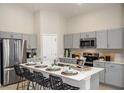 Stylish kitchen features modern stainless appliances, white quartz counters, grey cabinets and island seating at 37049 Sagemoor Dr, Zephyrhills, FL 33541